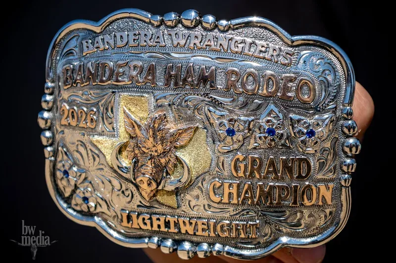 Engraved Bandera Wranglers Bandera Ham Rodeo Grand Champion lightweight belt buckle, silver with gold lettering and a boar head over a Texas outline.