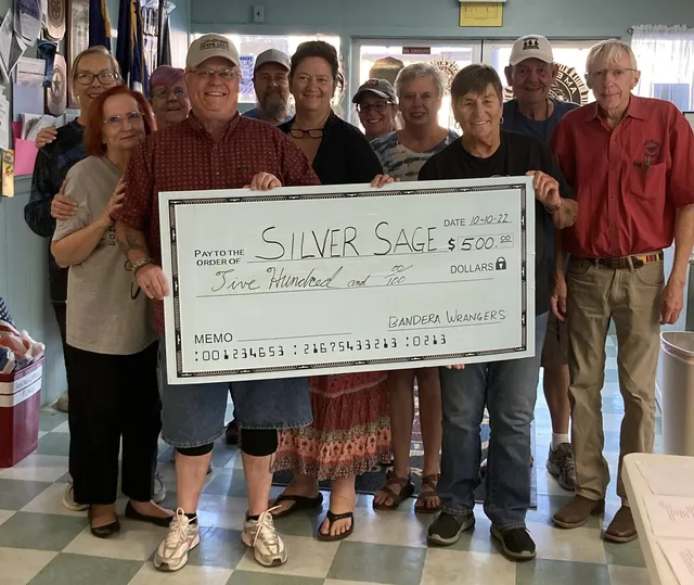 Bandera Wranglers members and friends holding a large five-hundred-dollar check made out to Silver Sage.